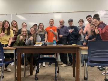 Students from the Honors Program stand in front of a desk.