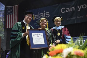 Professor of Occupational Therapy Mary Siniscaro stands between Provost Todd Pfannestiel and President Laura Casamento, holding her award at the 2023 Undergraduate Commencement Ceremony.