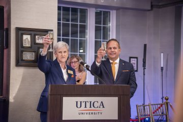 President Stephanie Nesbitt and John Calabrese hold up their glasses in a toast.