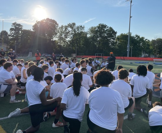 Players kneel on the field for A Call to Men Football Camp