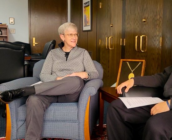 President Stephanie Nesbitt and Communication & Media major Neruda Perdomo ’26 sit in two chairs talking with each other.