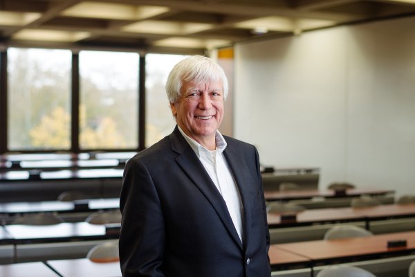 David Young Miller, Class of 1969, stands in a classroom smiling.